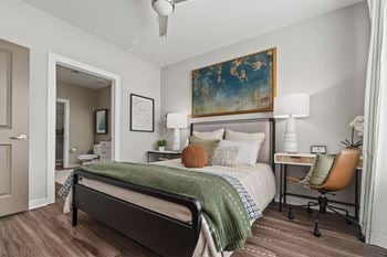 A bedroom with a bed, desk, and chair.